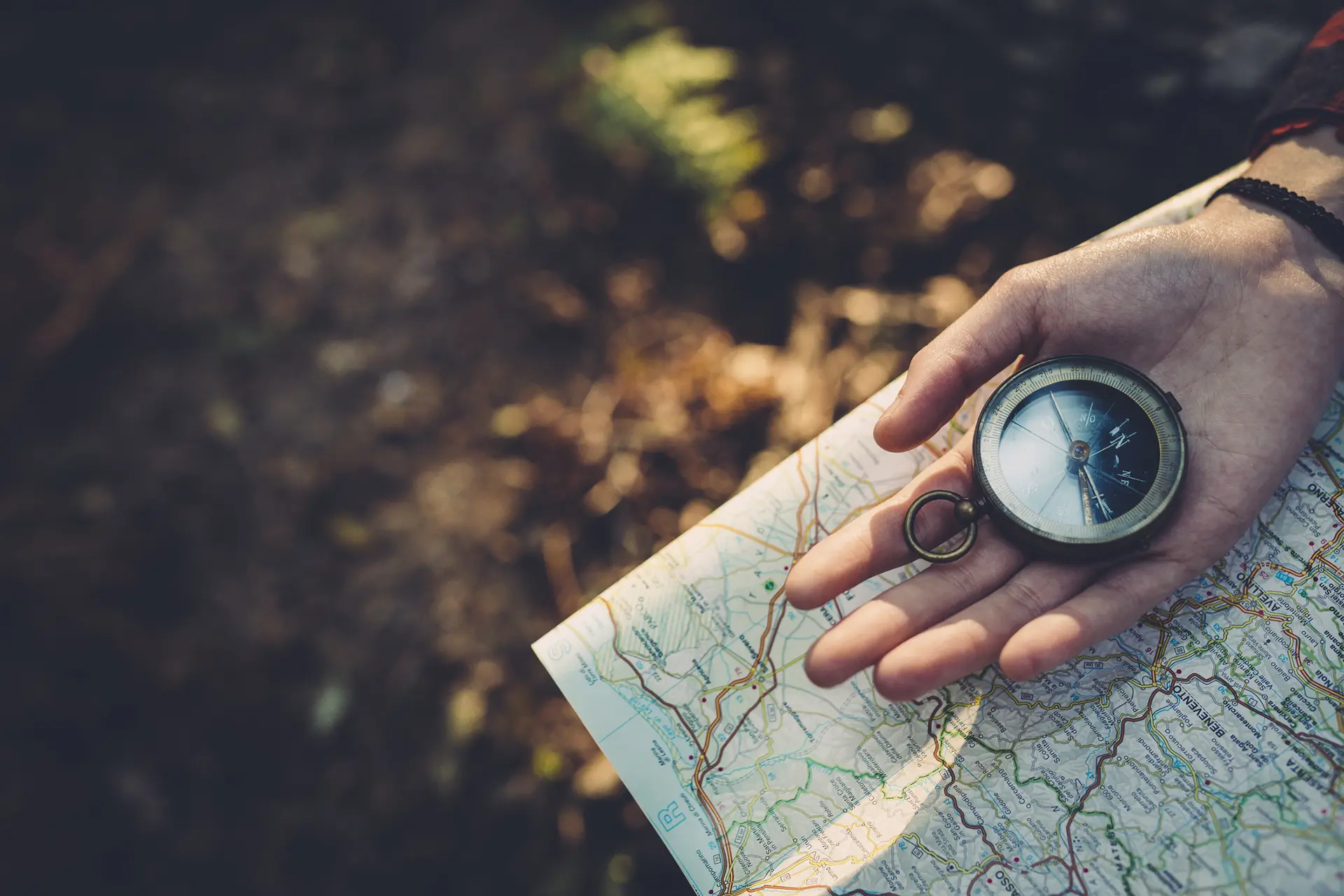 A person holding a compass and a map