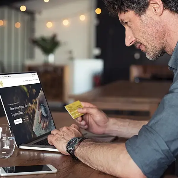 A person at a desk holding a payment card