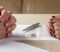 Hands of wife and husband signing divorce documents