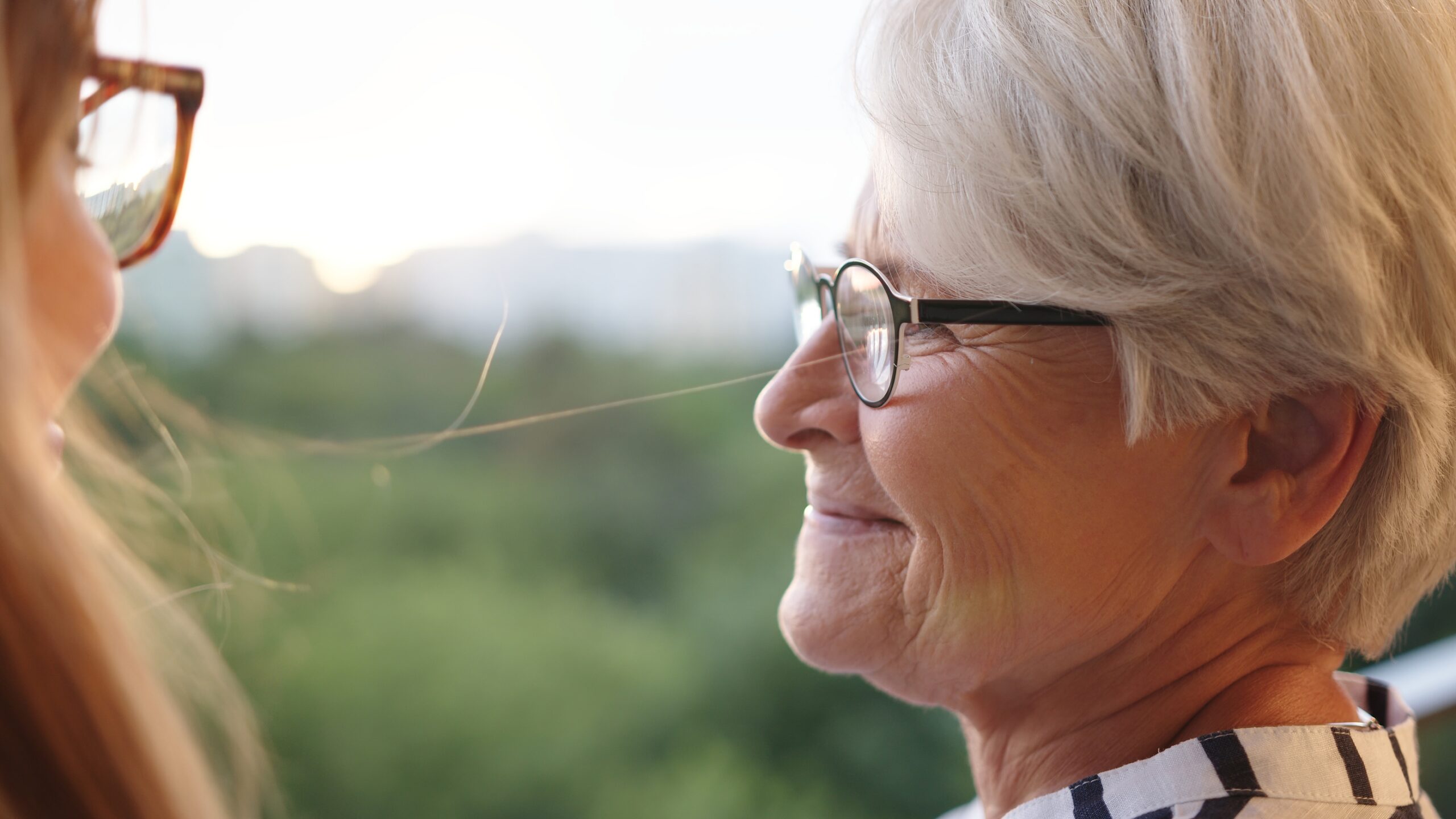 Close up shot of senior mother and adult daughter looking in at each other on the balcony