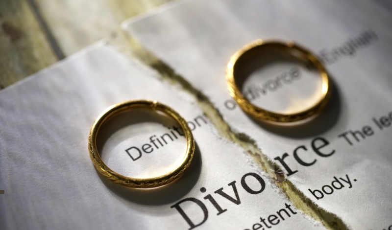 Image of two rings on a piece of paper with the word Divorce printed on it